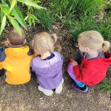 Young children playing and learning in the outdoors.