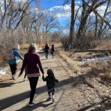 Pre-school children explore a paved trail with adults